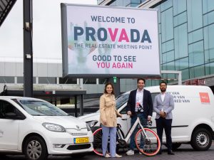 Beeld vlnr: Ingrid Staffhorst (CEO Hely), Michael Baan (Hely) en Moreno Monsanto (director concepts Rockfield Real Estate). Ze staan voor een bord waarop staat: 'Welcome to Provada: The real estate meeting point. Good to see you again' zoektermen: Hely Rockfield Provada PR Deelmobiliteitsleverancier Hely realiseert zeven nieuwe mobiliteitshubs in Eindhoven, Rotterdam en Amsterdam, samen met vastgoedontwikkelaar Rockfield en parkeerpartner ParkBee. De partijen maakten dit bekend bij de start van vastgoedbeurs PROVADA in RAI Amsterdam, waar Hely de enige exposant is in deelmobiliteit (stand 11.10).