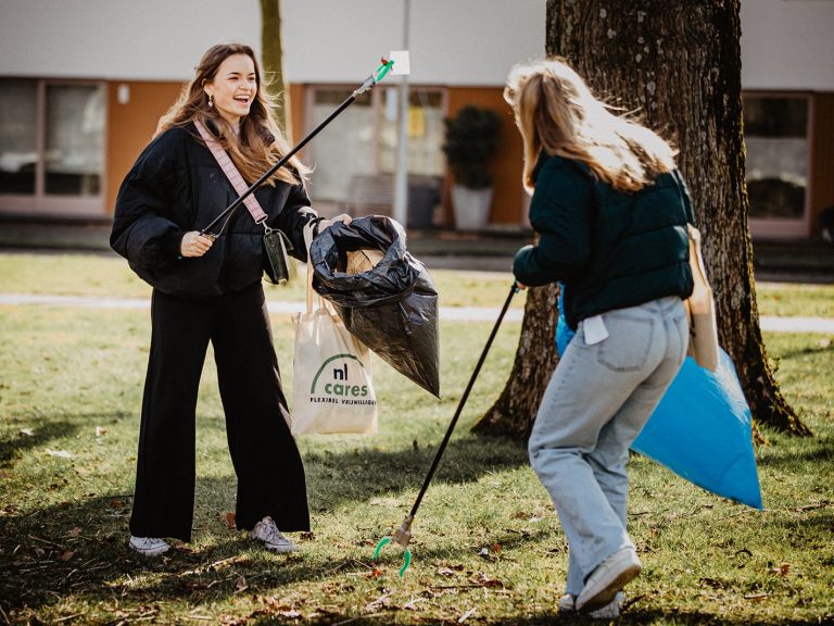 500 vrijwilligers gezocht voor nieuwe editie Nacht van de Vrijwilliger 2022 04 05 NL Cares Nacht NL Cares organiseert op donderdag 21 april 2022 de Nacht van de Vrijwilliger in Amsterdam, Rotterdam, Den Haag en Utrecht. Afgebeeld staan twee meiden van begin 20 die samen vuil prikken. Ze hebben er zichtbaar plezier in.